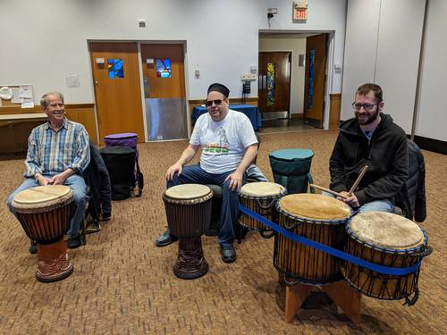 Three members of the drum circle, showing off some special rare African drums